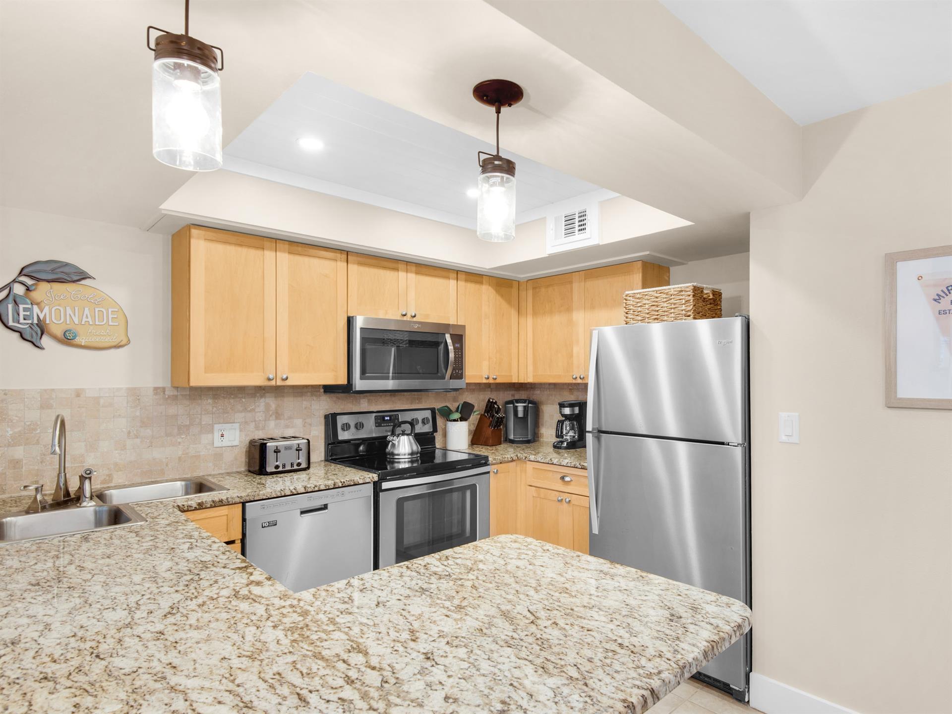 Your fully equipped kitchen features granite countertops, stainless steel appliances, and warm wood cabinetry—perfect for preparing meals together.