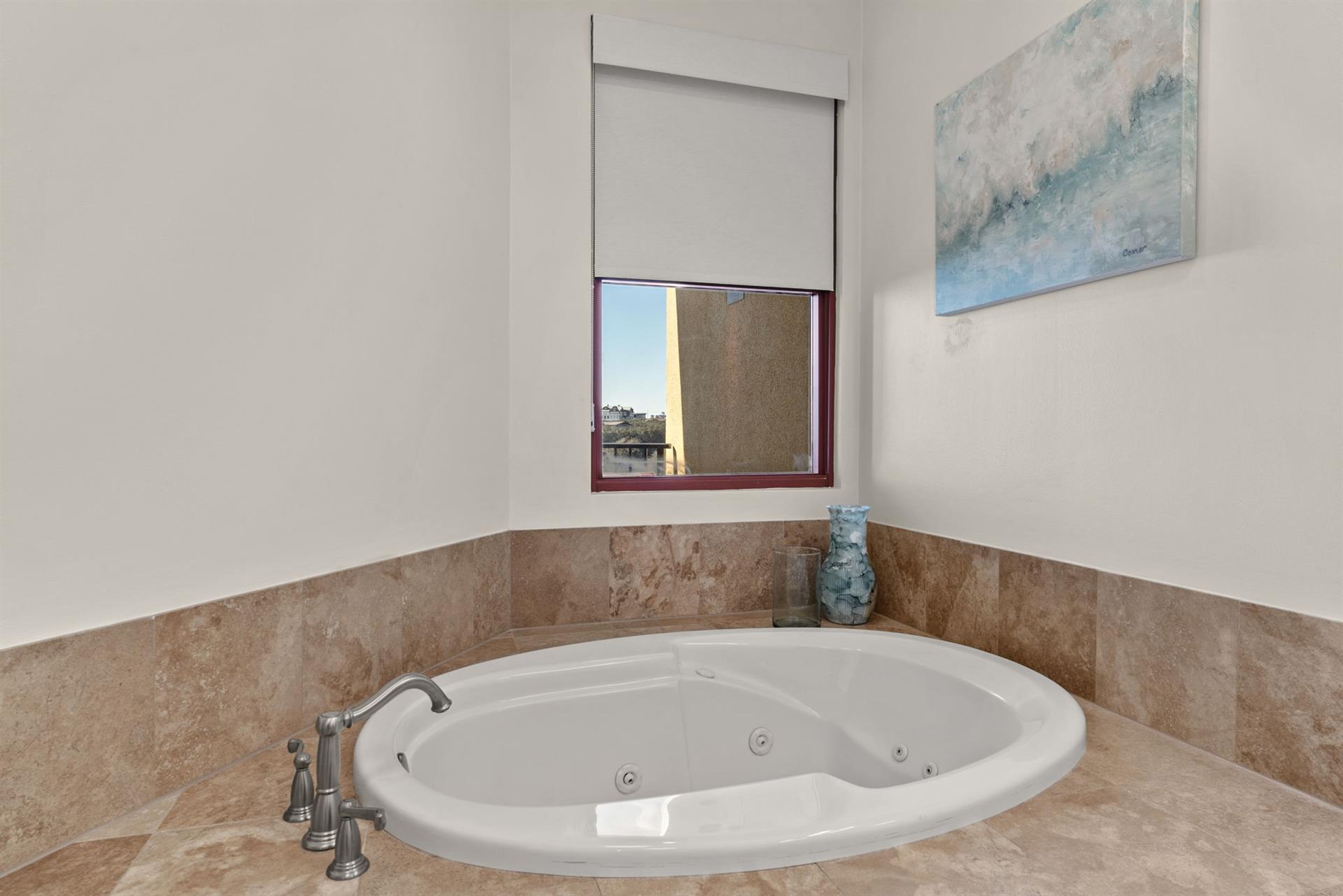 Sink into your private jetted tub, surrounded by warm tile and coastal views from your window.