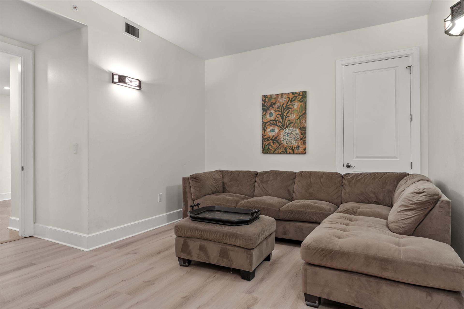 Unwind in your spacious tv room area featuring a plush sectional sofa and modern touches that create the perfect retreat.