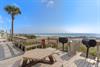 Community beachfront BBQ deck with stunning gulf views features grills and picnic table for your perfect seaside cookout.