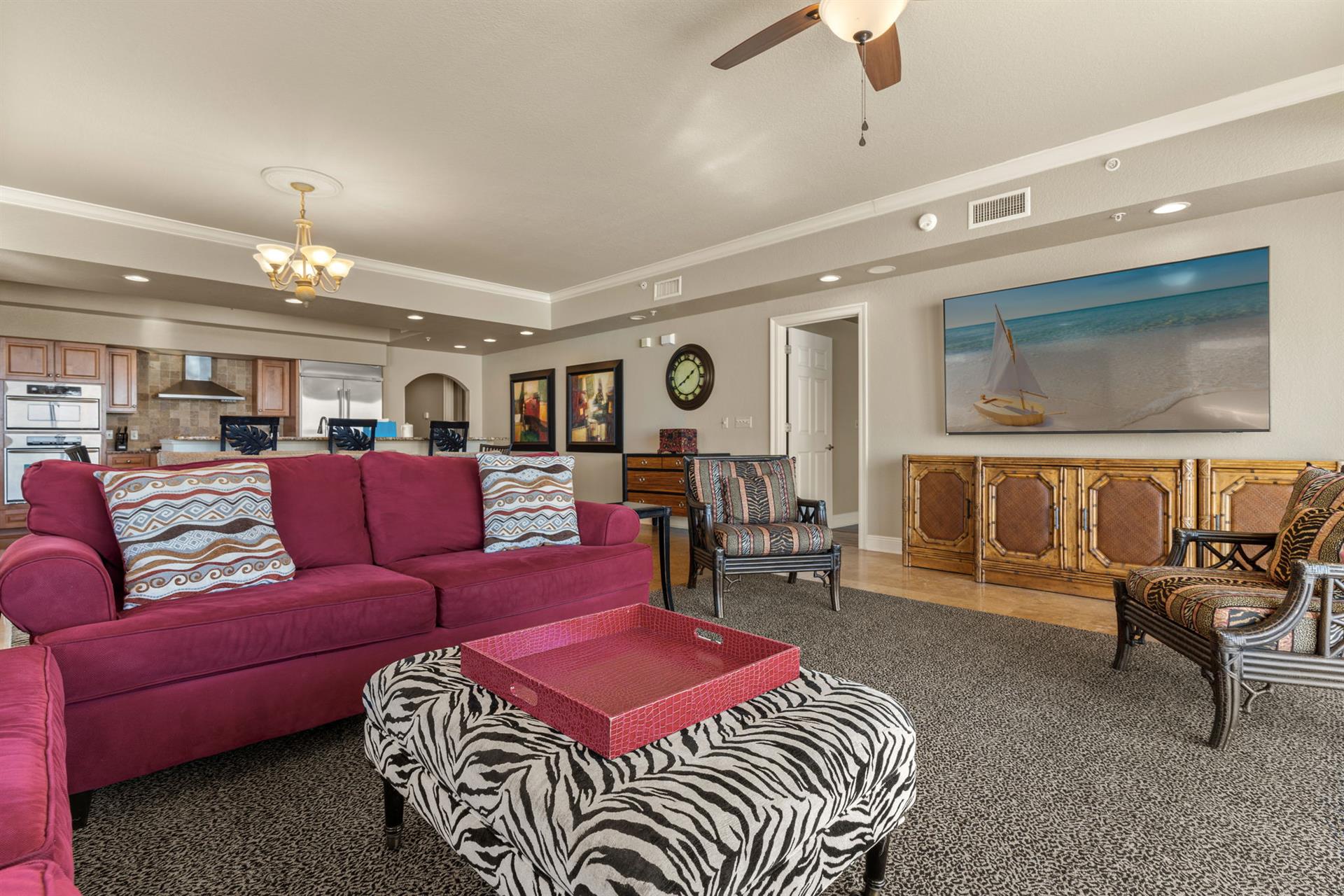 Unwind in your spacious living room where rich burgundy seating and coastal artwork create the perfect retreat after exploring.