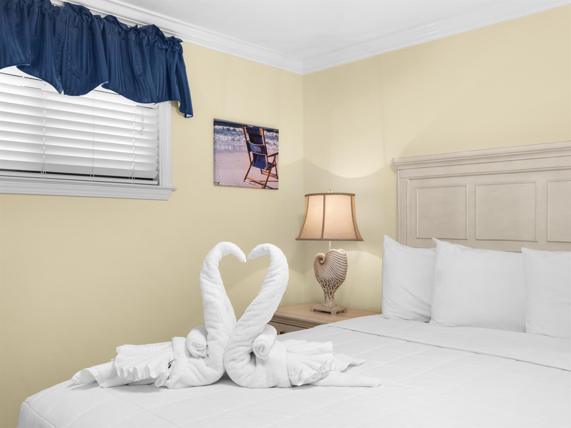 Sink into your cozy bedroom where crisp white linens and thoughtful towel swans await your arrival for a truly welcoming stay.