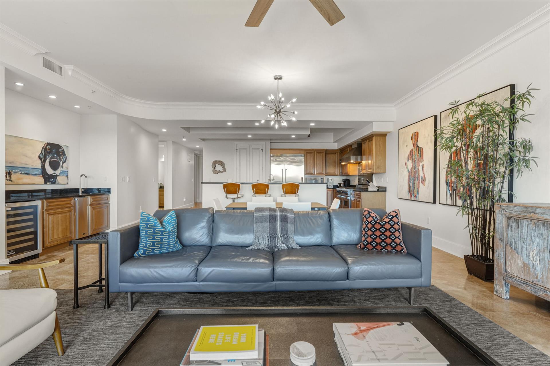Sink into this stylish blue leather sofa and enjoy the openconcept living with modern kitchen, artistic touches, and warm wood accents throughout.