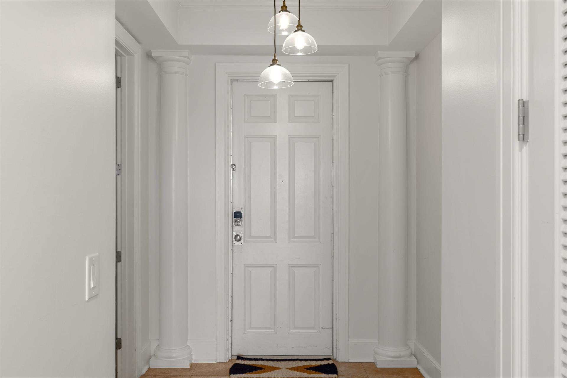 Step into your elegant entryway with soaring columns, warm pendant lighting, and classic details that welcome you home.