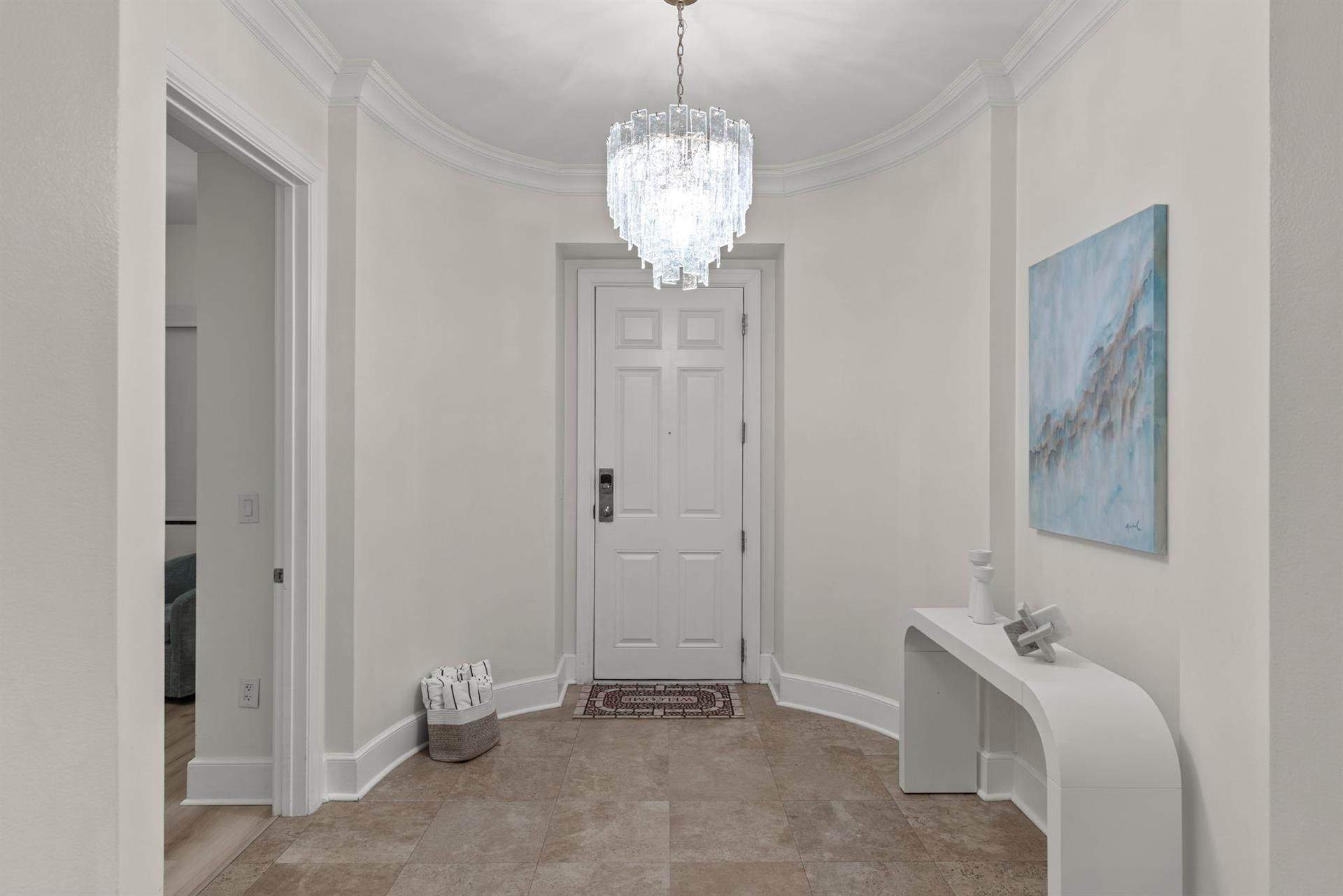 Step into your elegant foyer where crystal chandelier light dances across pristine walls, creating an instantly welcoming atmosphere for your stay.