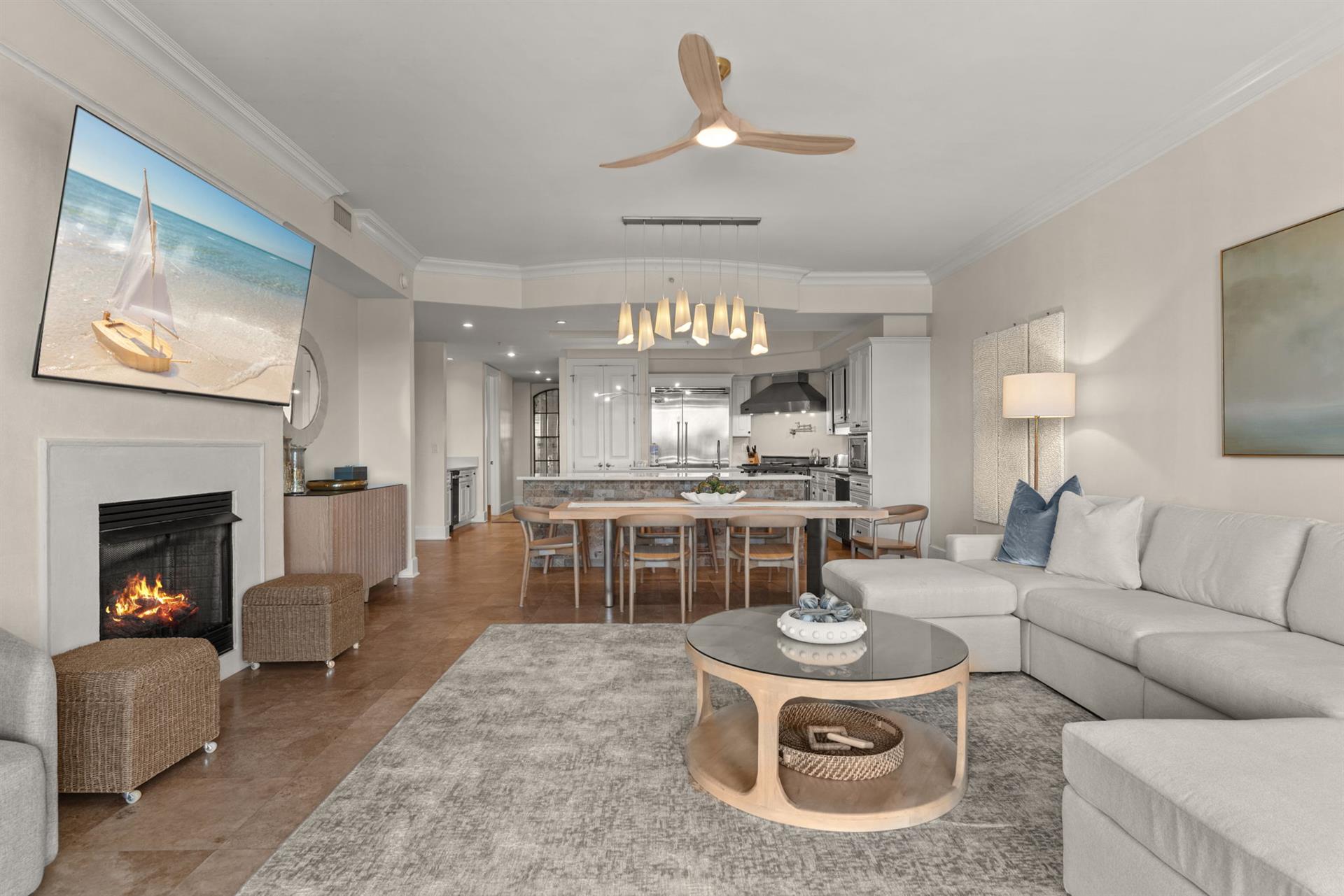 Unwind in your elegant living space where modern comfort meets coastal charm, complete with a crackling fireplace and open kitchen.