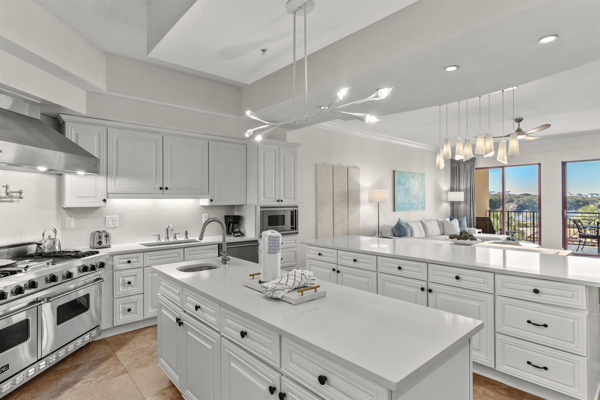 Your spacious gourmet kitchen features gleaming white cabinetry, premium appliances, and stunning views through floortoceiling windows.