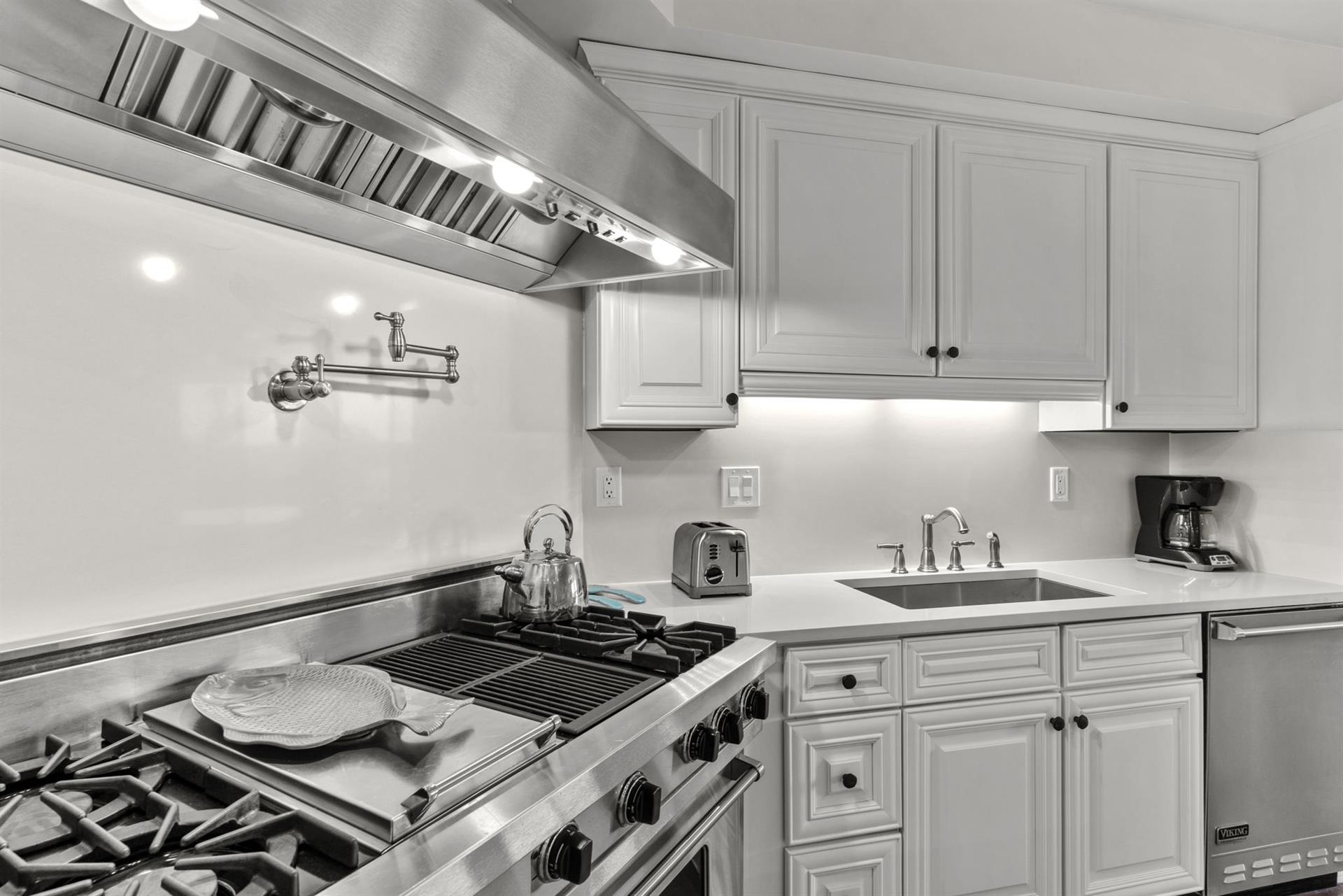 Your fully equipped kitchen features professionalgrade stainless steel appliances and elegant white cabinetry, perfect for preparing memorable meals during your stay.
