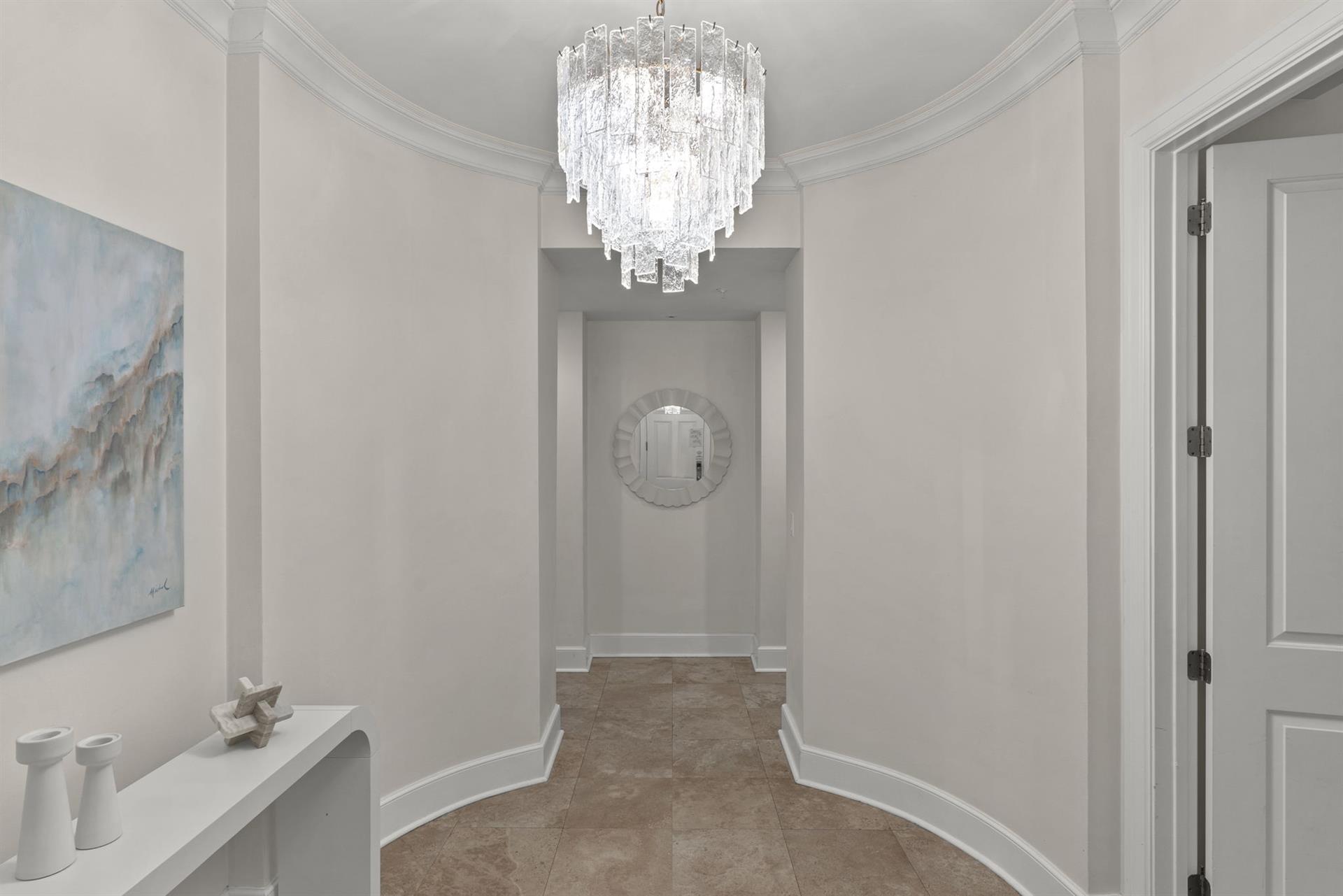 Step into elegant sophistication beneath a stunning crystal chandelier that illuminates your grand entrance hallway.