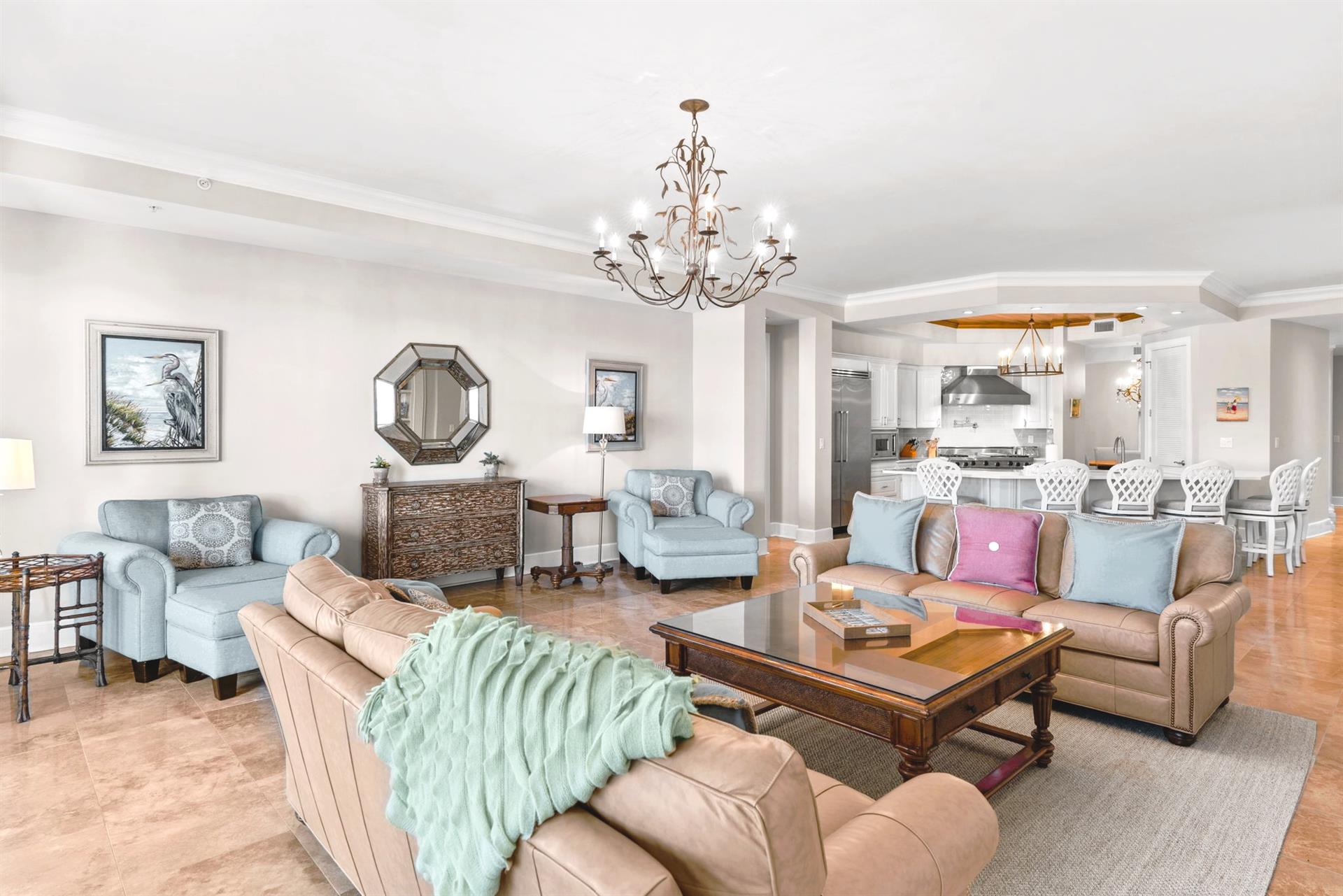 Sink into plush leather sofas in your elegant living space, where coastal art and soft blue accents create a serene retreat.