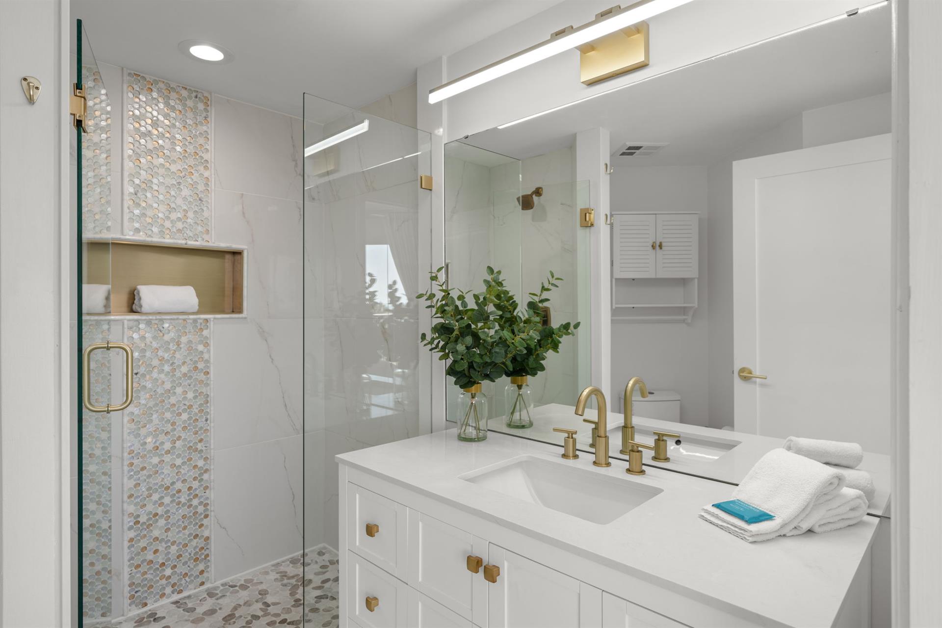 Indulge in the spalike bathroom 2 with elegant gold fixtures, luxurious walkin shower, and pristine white finishes that create your perfect retreat.