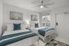 Rest peacefully in the coastal twin bedroom 3 with soft blues, ceiling fan, and nautical artwork creating the perfect seaside retreat.