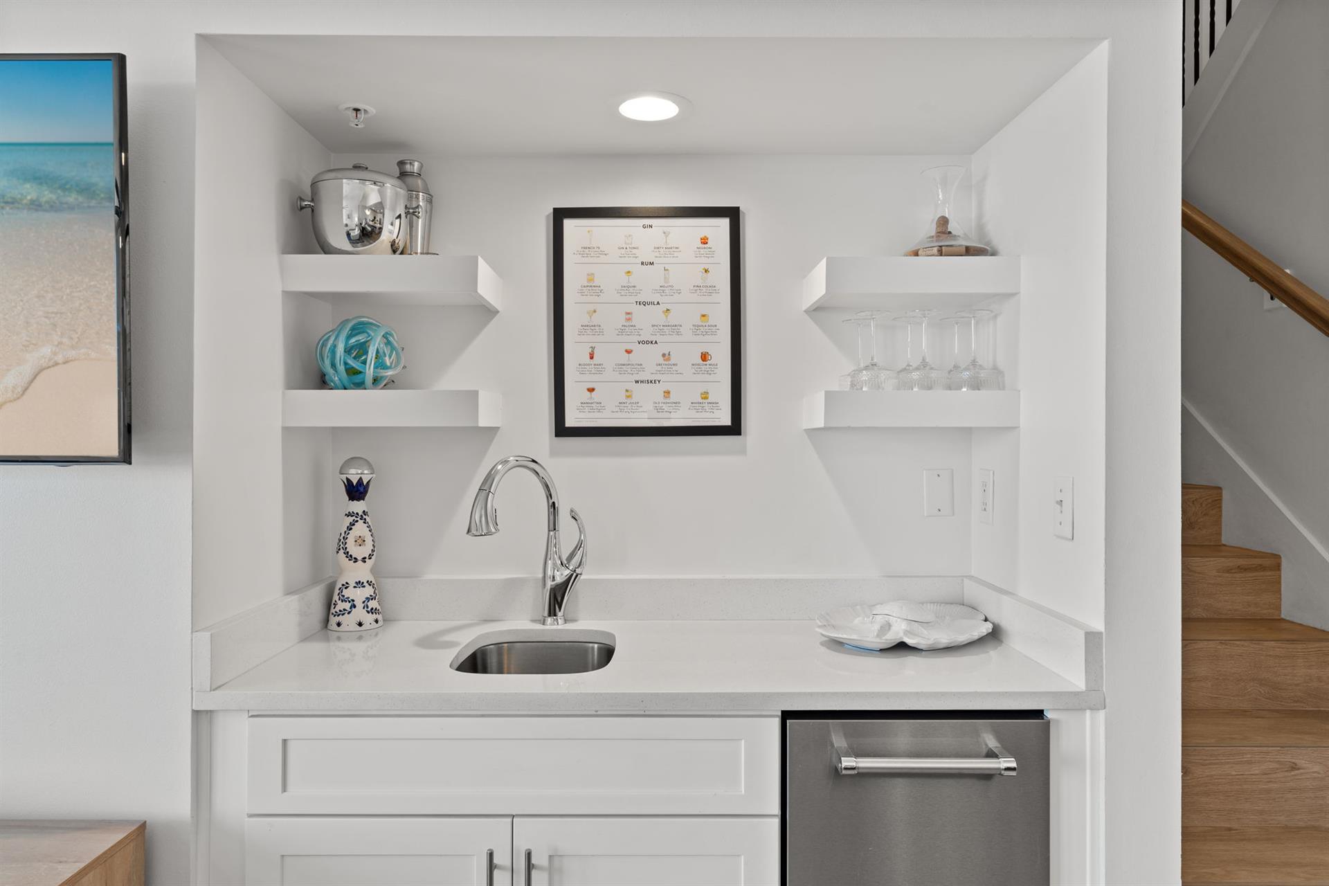 Stylish open shelving complements the sleek wet bar.