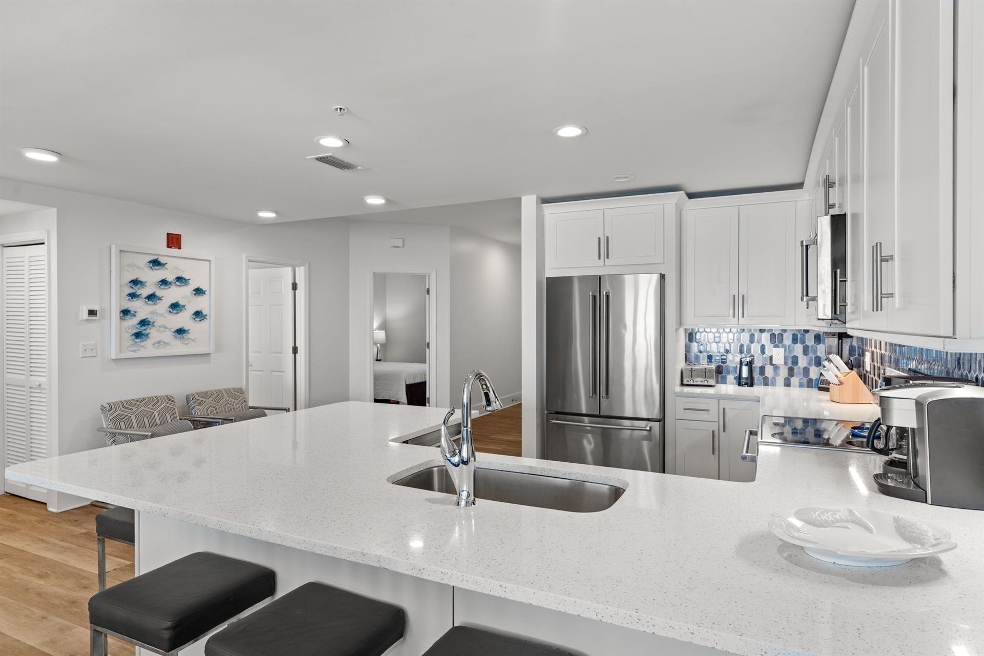 Sleek white cabinets and blue mosaic backsplash make cooking more fun