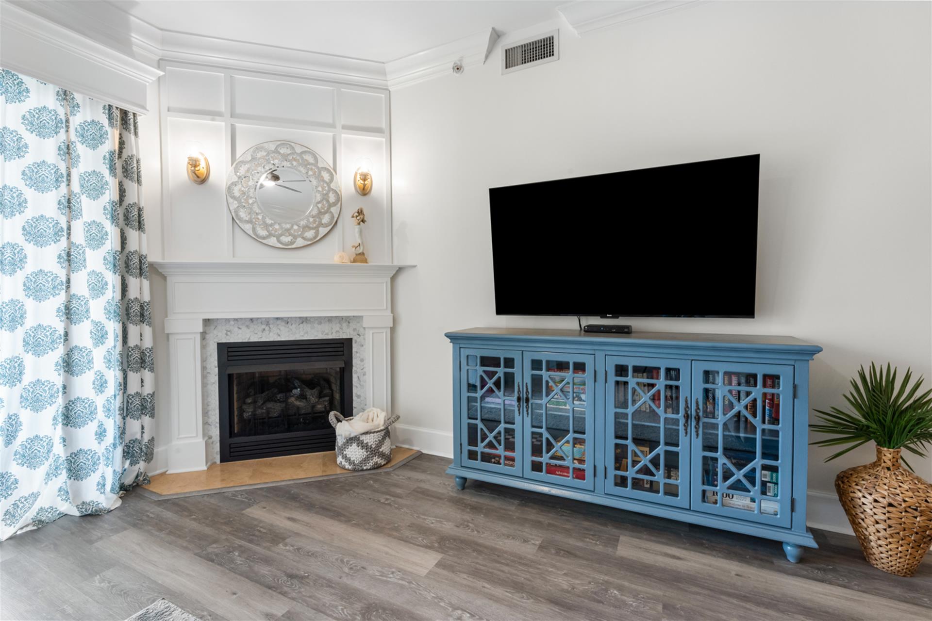 Gather in the living area with a large TV and a stunning custom fireplace mantel.