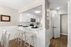 The modern kitchen features crisp white cabinetry and a breakfast bar