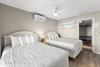 Bedroom 3 offers comfort with two plush Queen beds, climate control, and coastal artwork