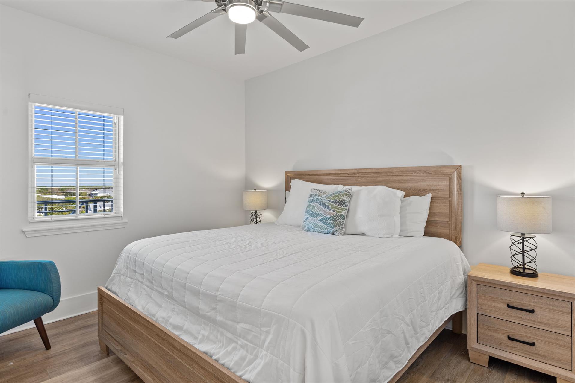 The 1st floor king bedroom with soft linens and warm wood accents.