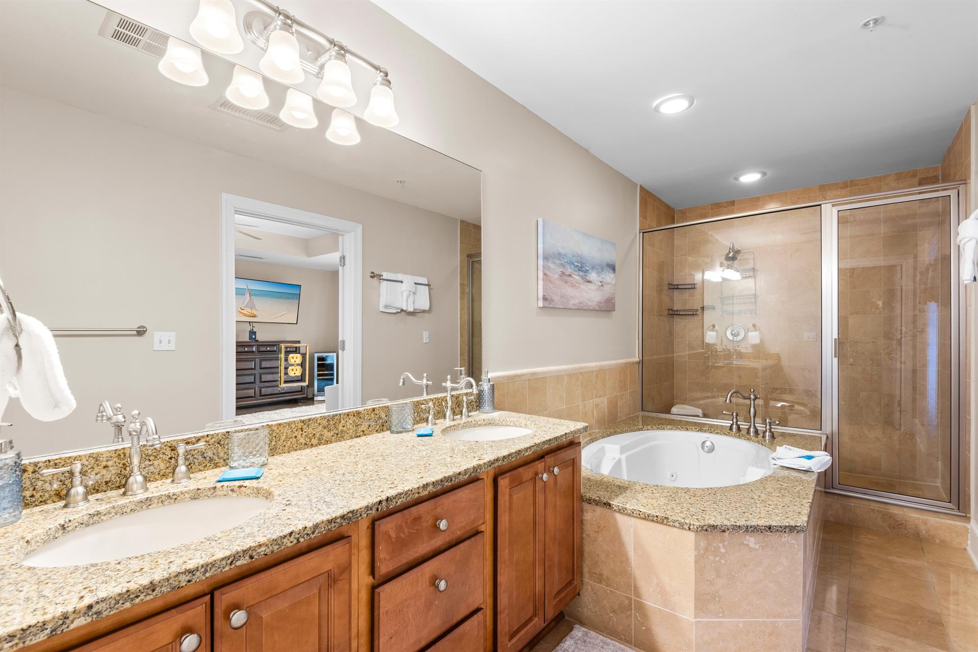 Unwind in the luxurious ensuite featuring a soaking tub, granite countertops, and elegant tile finishes—your personal spa retreat after a long beach day.