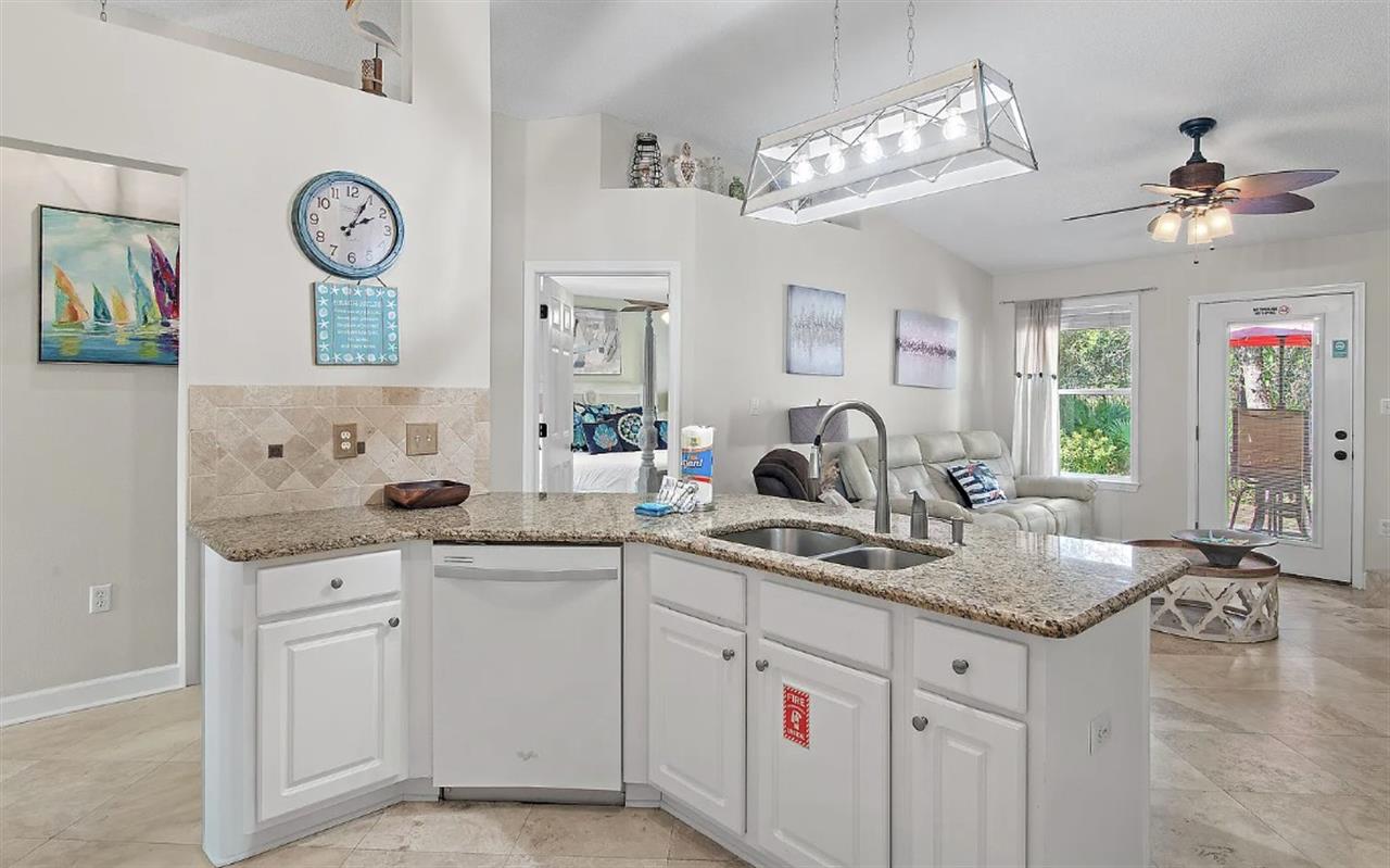 Whip up your morning coffee in this bright, open kitchen featuring granite counters and modern appliances, perfectly connected to your cozy living space.