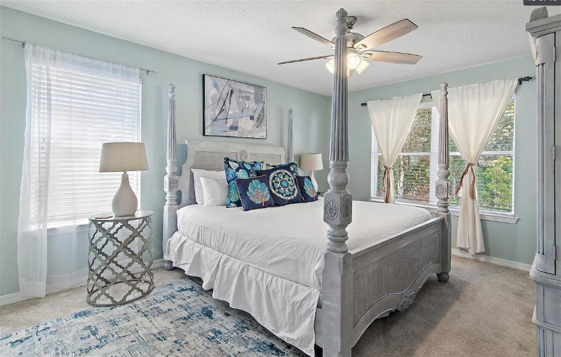 Bedroom 1  Unwind in your elegant fourposter bed beneath a gentle ceiling fan, where coastal blues and crisp linens create the perfect retreat.