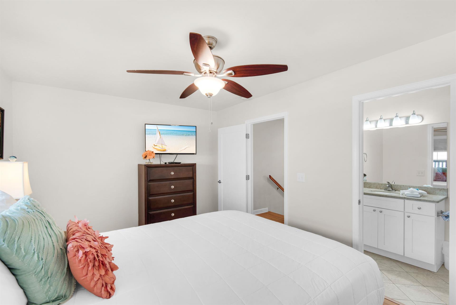 Your bright master bedroom features crisp linens, coastal touches, and an ensuite bathroom for ultimate comfort and convenience.