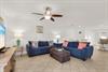 The spacious living area has plush navy sectional seating  and seasonal decor