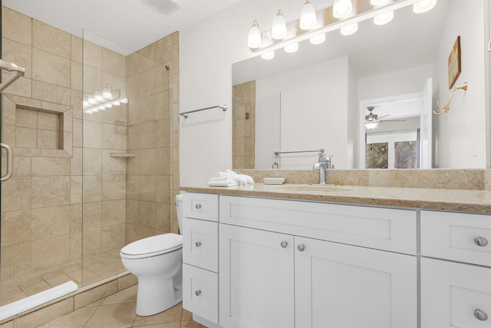 Bathroom 1 features a walkin shower and granite counters