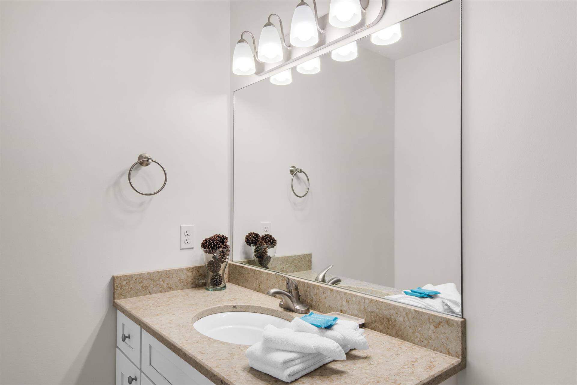 Bathroom 2 also features granite counters and bright vanity lighting
