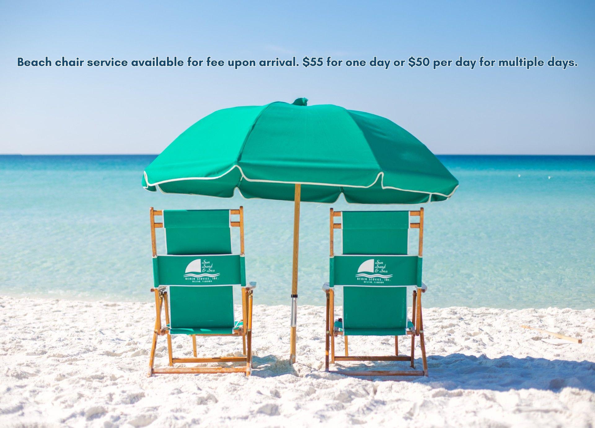Two beach chairs and umbrella set up on pristine white sand facing turquoise waters.