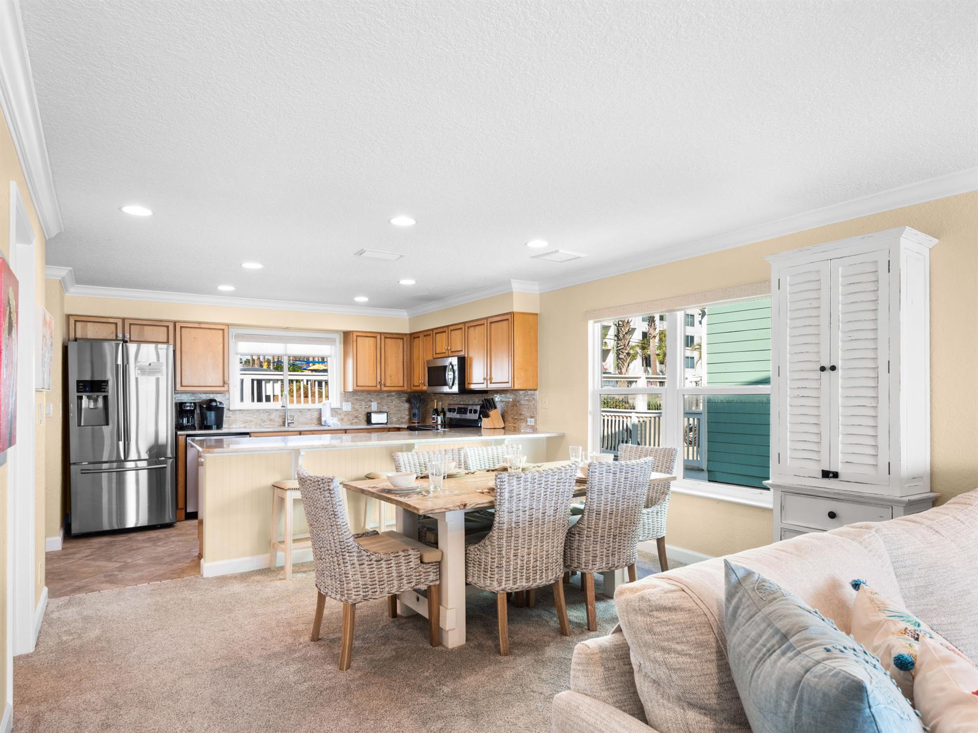 The spacious openplan living area seamlessly blends kitchen, dining, and lounge spaces with coastalinspired furnishings and abundant natural light.