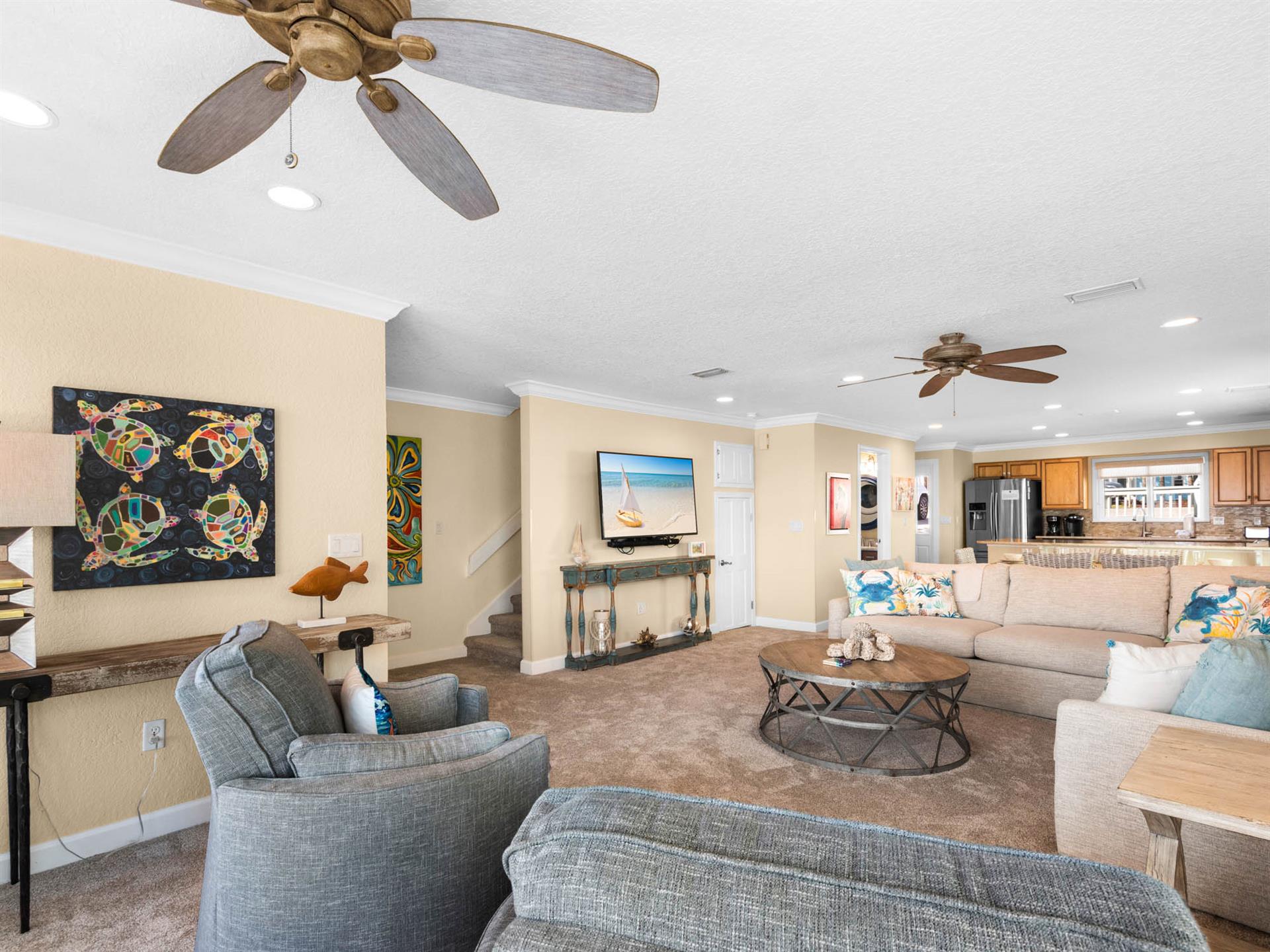 Relax in the spacious living area with coastal décor, comfortable seating, and a fully equipped kitchen.