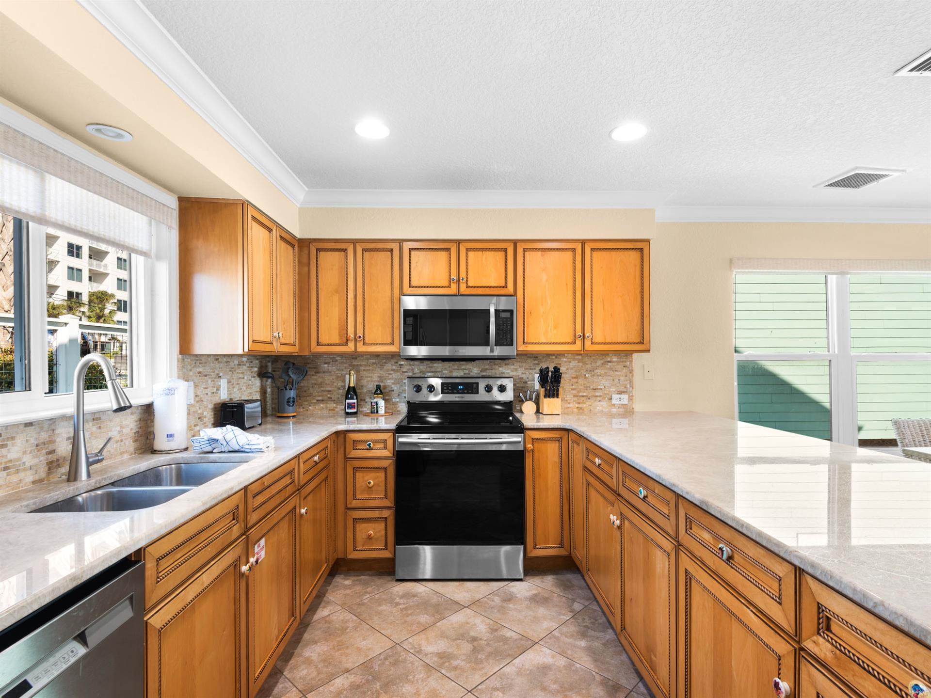 The fullyequipped kitchen invites culinary adventures with warm wood cabinets, granite counters, and modern appliances for memorable meals.