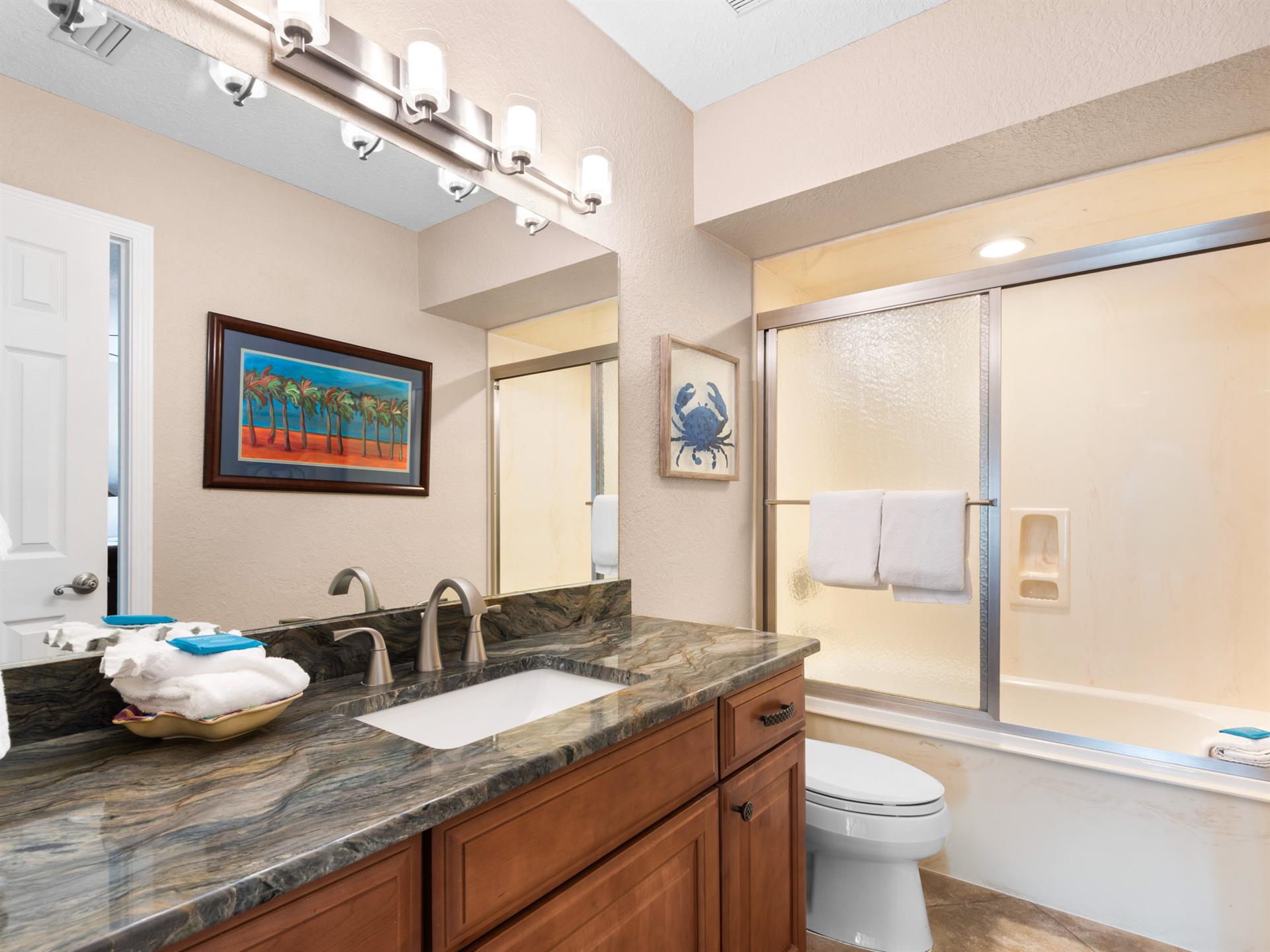 Freshen up in yourGuest bathroom with marble counters, and a modern glass shower.