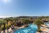 2114 views from the balcony showcase the sparkling swimming pool framed by palm trees, with beautiful coastal waters and natural landscape beyond
