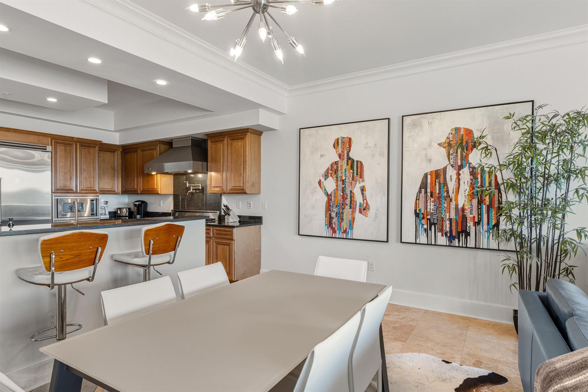 Gather around this sleek dining table where your group can share meals while admiring the contemporary art and open kitchen.