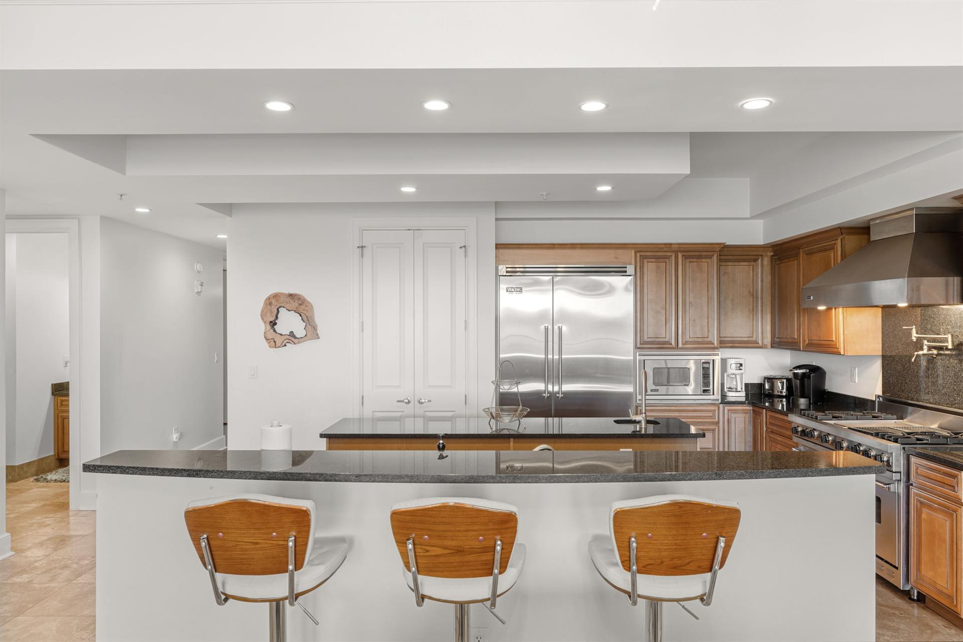 The gourmet kitchen awaits with sleek granite counters, stainless steel appliances, and a breakfast bar perfect for morning coffee.