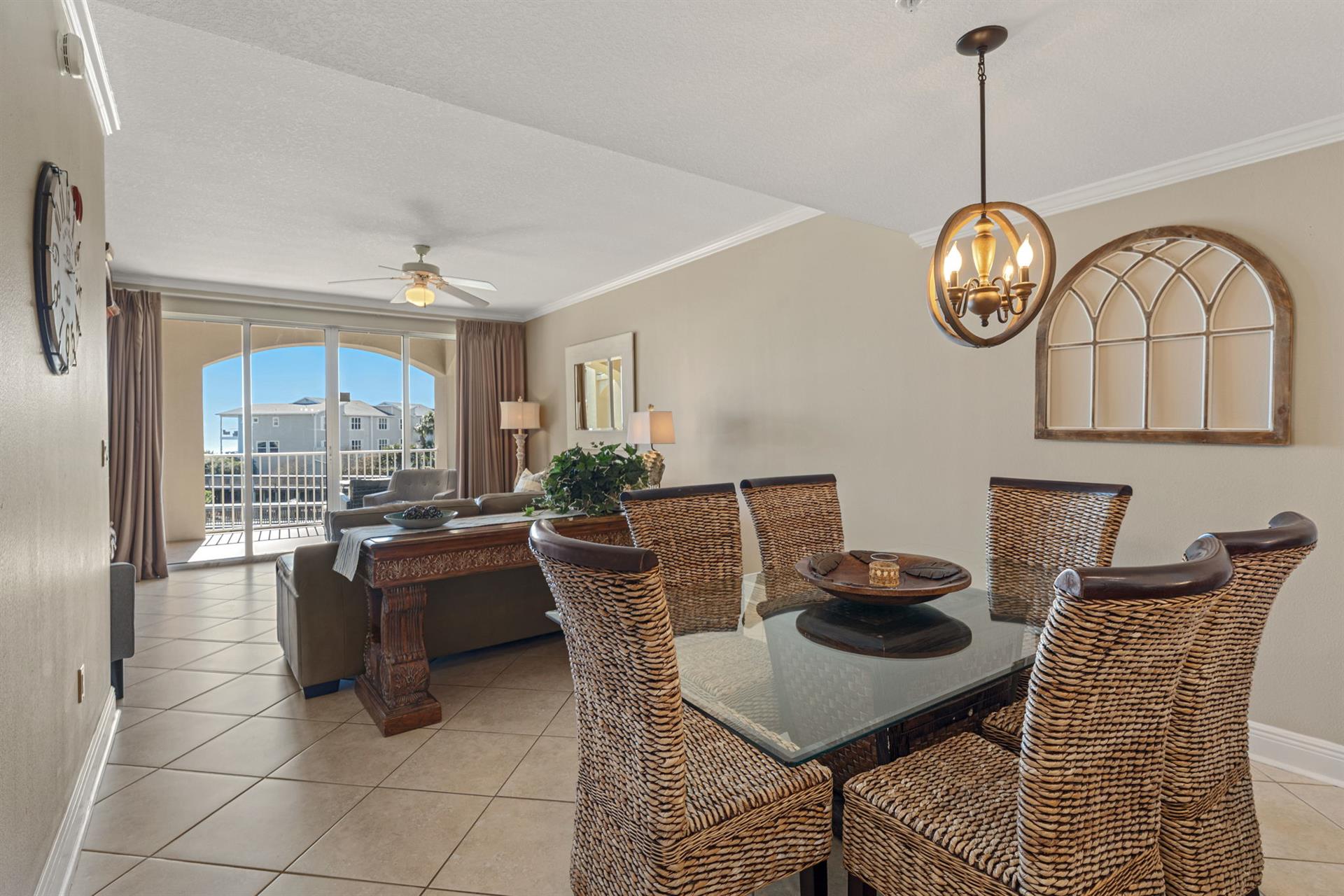 Gather around the elegant dining table with wicker chairs, where natural light floods in through arched windows overlooking the neighborhood.