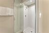 Step into the private glassenclosed shower with fresh white tiles and plush towels ready for your comfort.