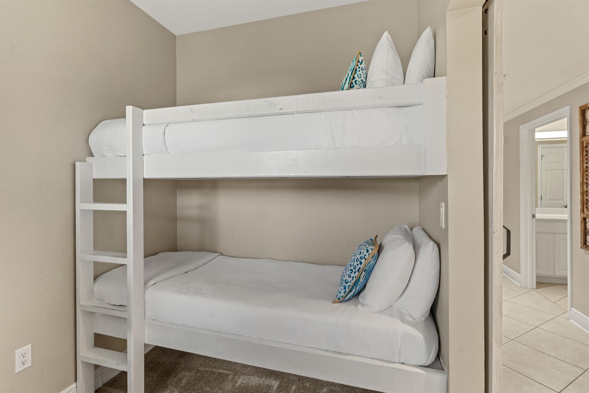 Cozy bunk beds with crisp white linens and cheerful blue accents create the perfect space for your familys comfort.