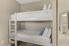 Cozy bunk beds with crisp white linens and cheerful blue accents create the perfect space for your familys comfort.