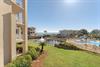 Beachfront resort community with swimming pool, landscaped grounds, and coastal access via boardwalk.