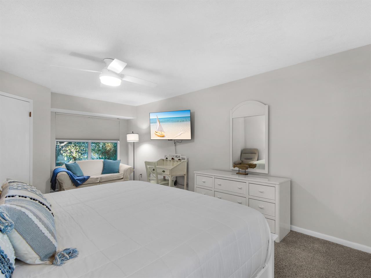 Bedroom 1  Sink into your plush bed while enjoying the cozy seating nook and calming coastal artwork that creates your perfect retreat.