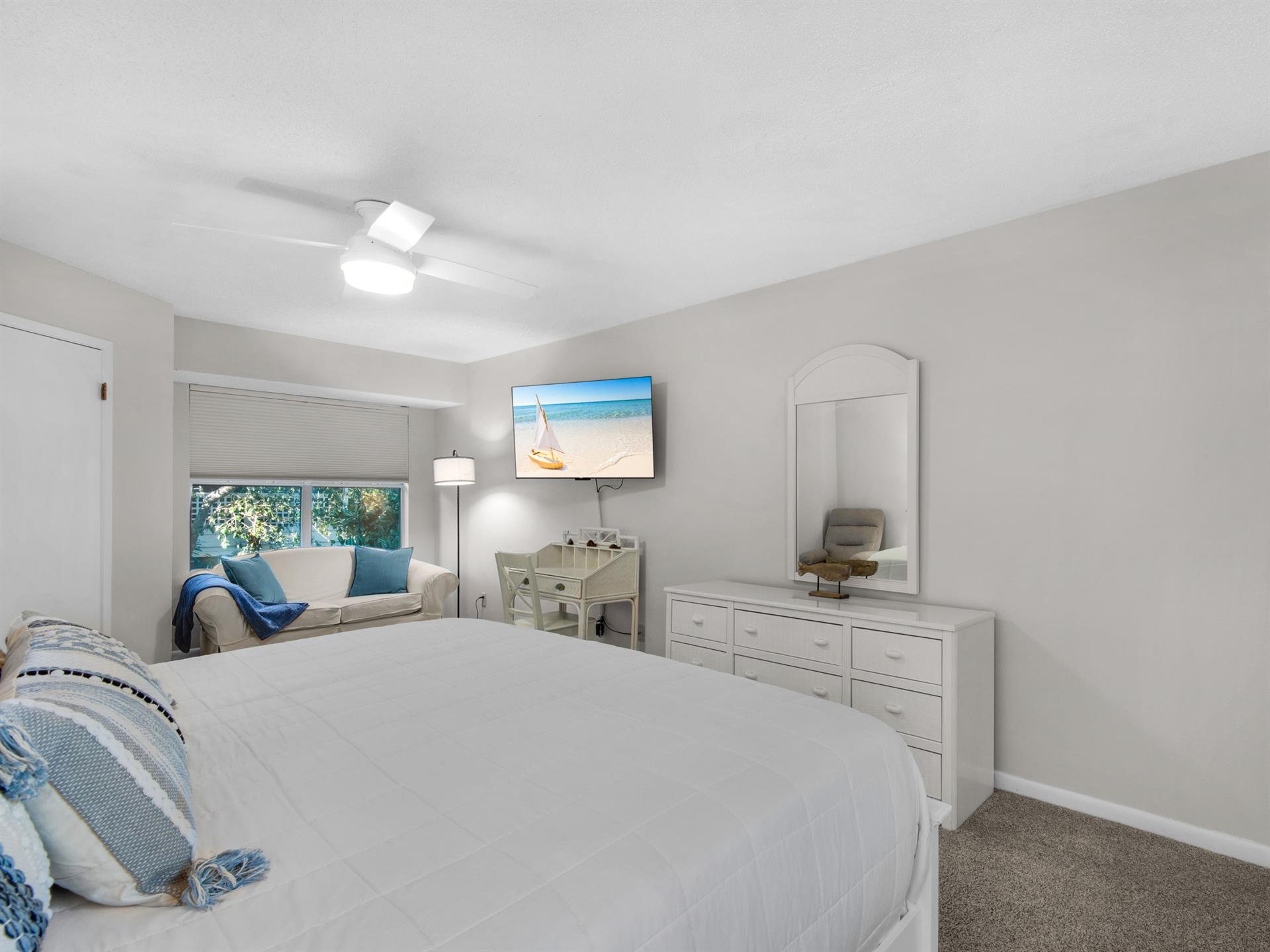 Bedroom 1  Sink into your plush bed while enjoying the cozy seating nook and calming coastal artwork that creates your perfect retreat.