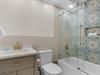 Bathroom 2  Step into your stylish bathroom featuring gorgeous patterned tiles, modern fixtures, and a luxurious glassenclosed tub shower combo.