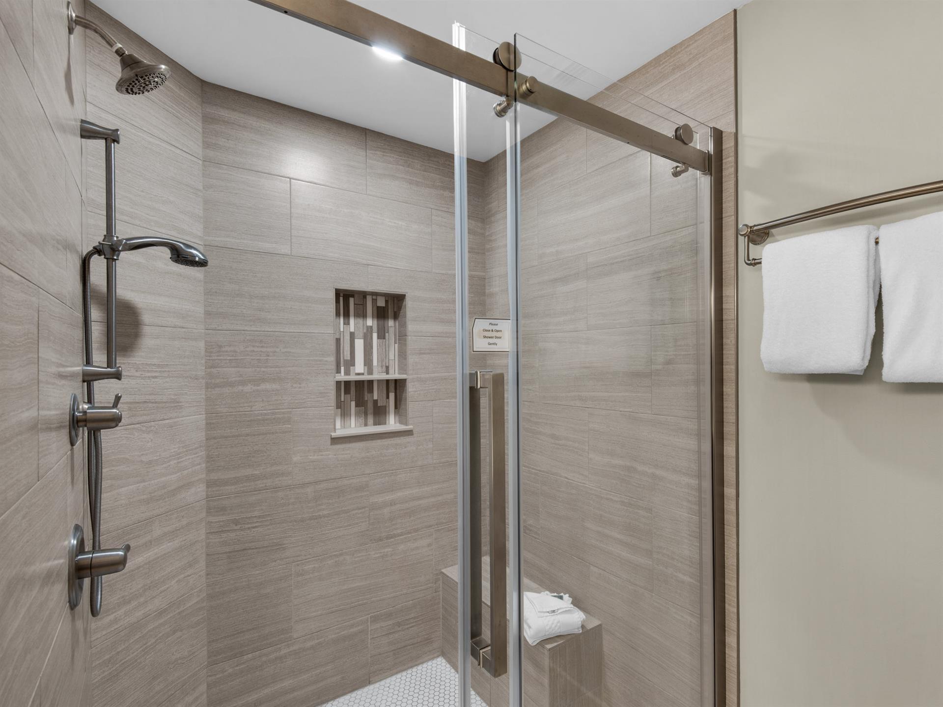 Bathroom 1 Step into your spacious glassenclosed shower with elegant woodgrain tiles and modern fixtures for your daily refresh.