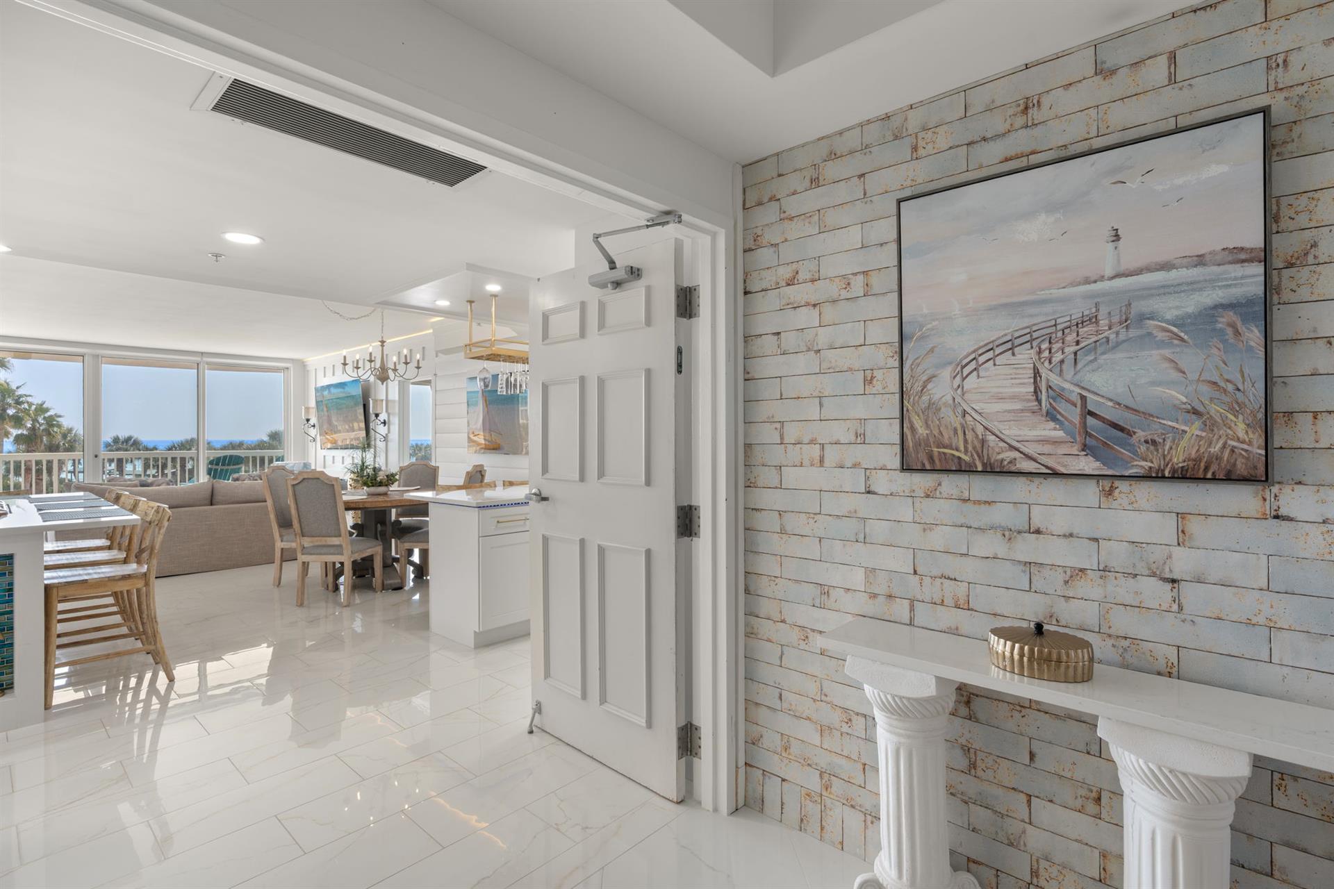Step into your elegant coastal retreat with bright marble floors, artistic brick accents, and open living spaces that flow beautifully together.