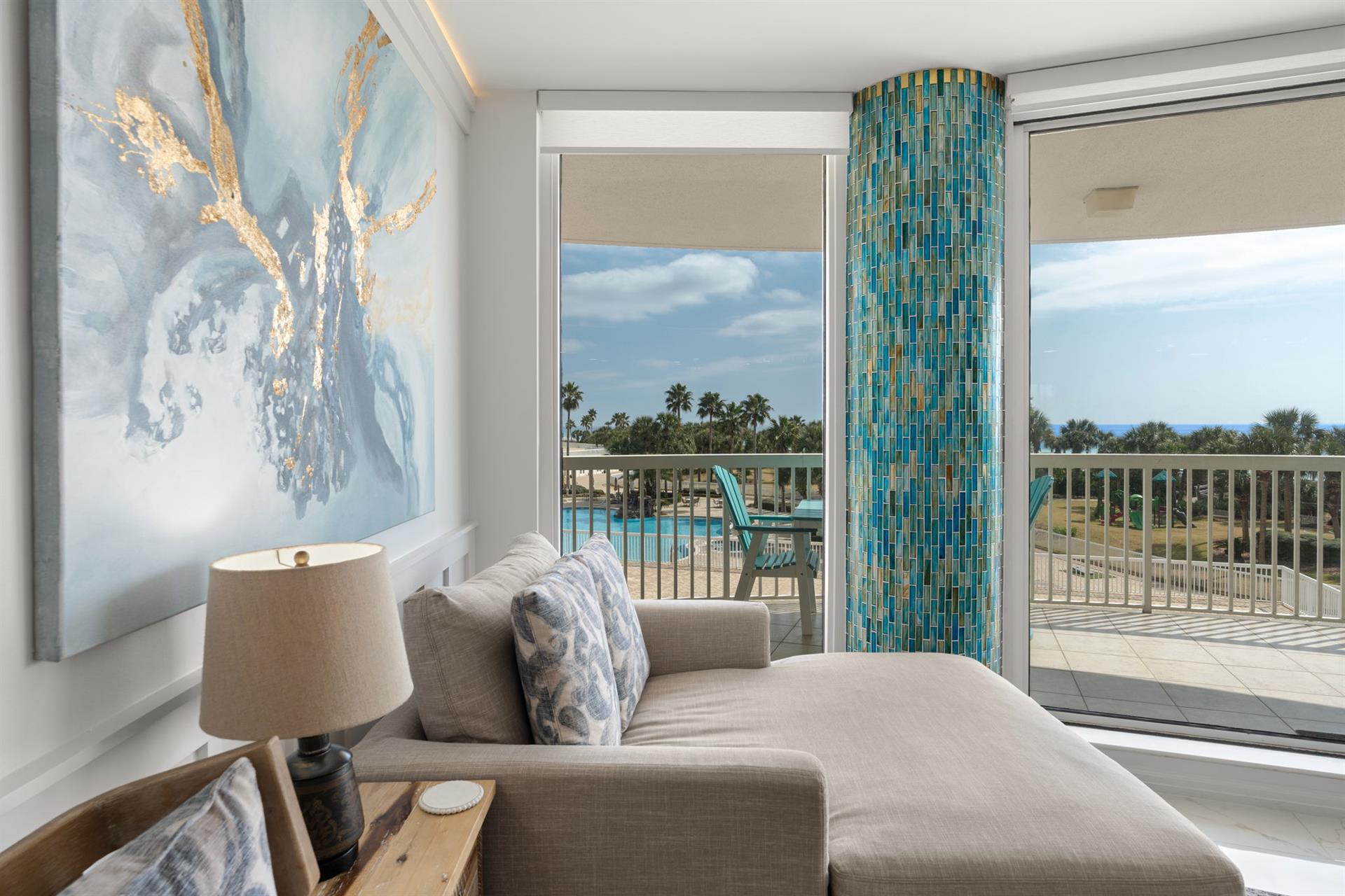 Sink into plush seating while gazing at stunning pool views through floortoceiling windows in your bright, coastalinspired retreat.