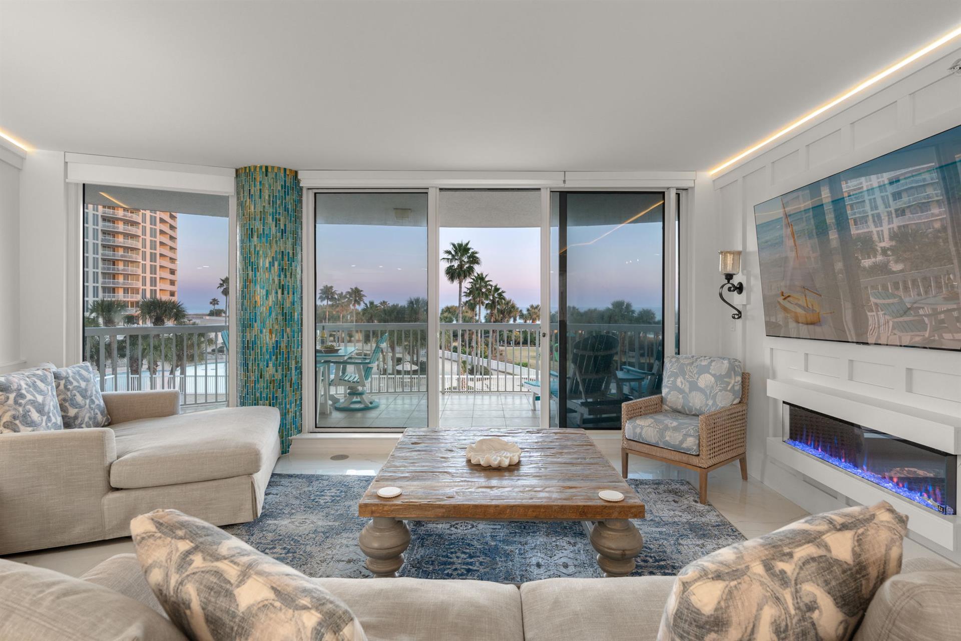 Relax with stunning water views, cozy fireplace, and direct balcony access to tropical scenery.