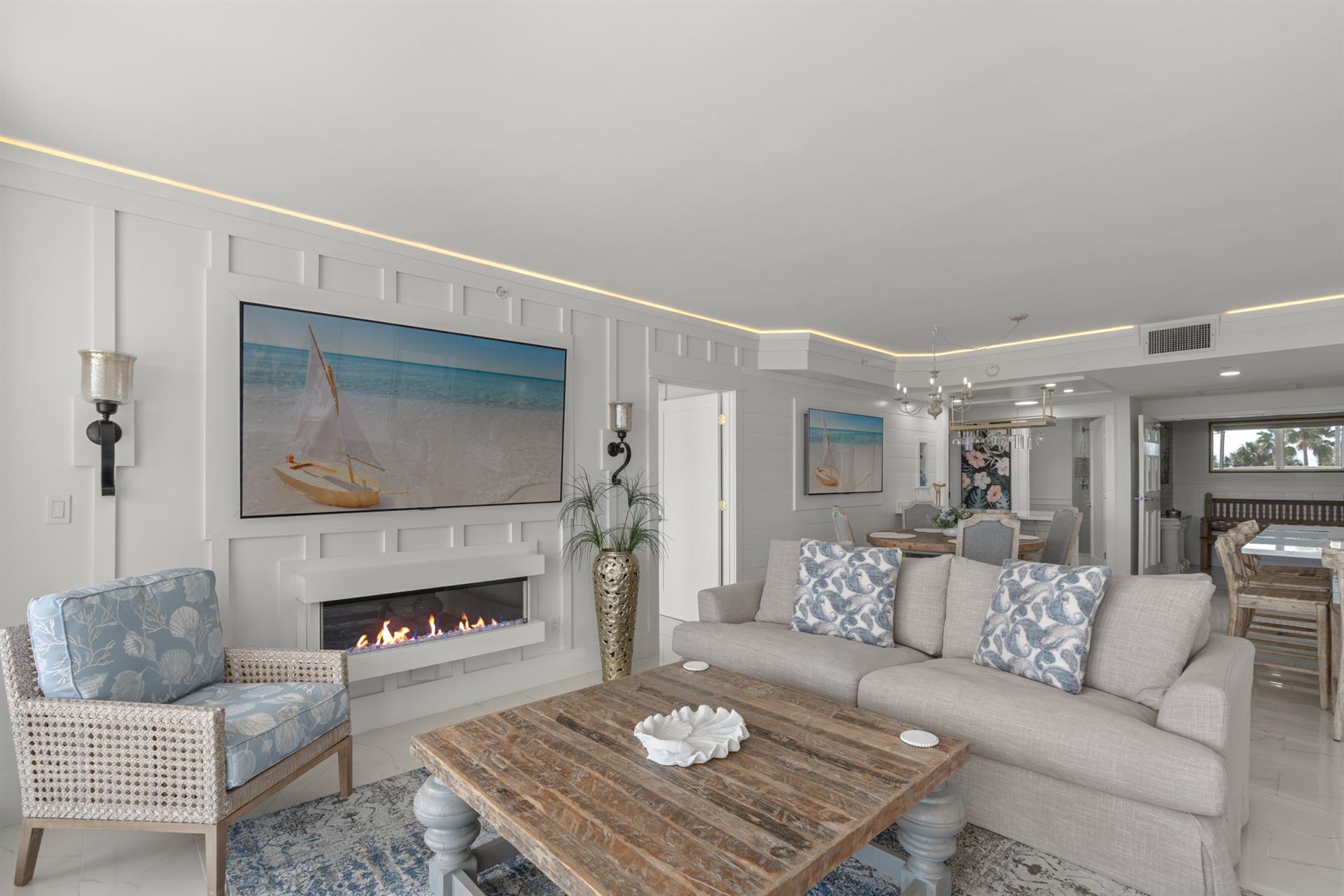Sink into plush coastalinspired seating by your modern fireplace, where ocean artwork and soft lighting create your perfect retreat.
